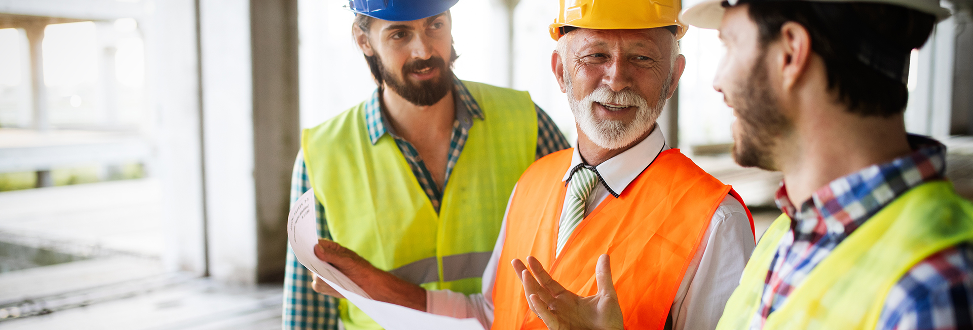 Construction Engineers In Discussion With Architects At A Building Site